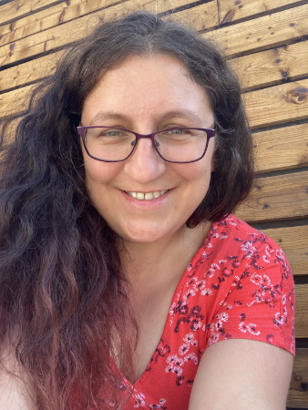 Relaxed outdoor portrait of a female graphic designer in a casual setting.